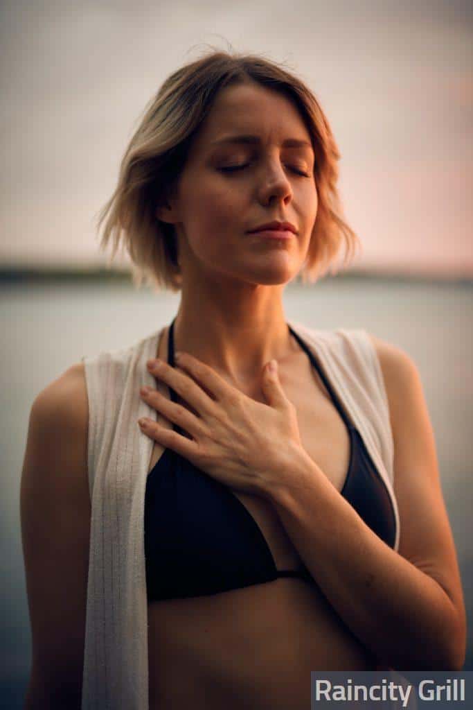 woman in white vest and black bikini with hand on chest
